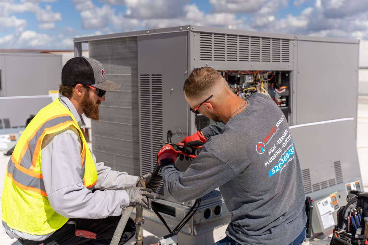 Two Done Rite Services technicians repairing a rooftop unit in the Tucson area