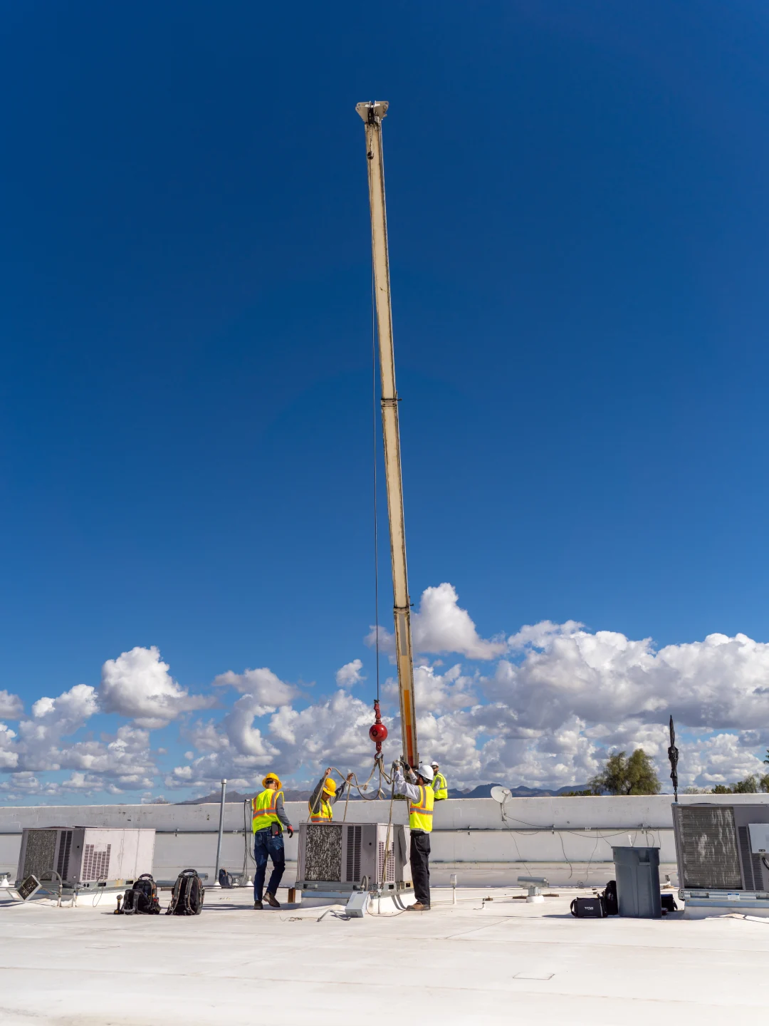 Rooftop HVAC unit being lifted into position by crane during an installation
