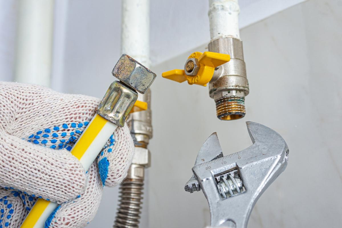 Flexible gas connector and shutoff valve being fitted by a technician