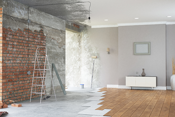 Room shown part renovated and part finished, with bare brick beside completed wall and flooring
