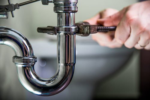 Close-up of a sink trap being serviced during drain cleaning
